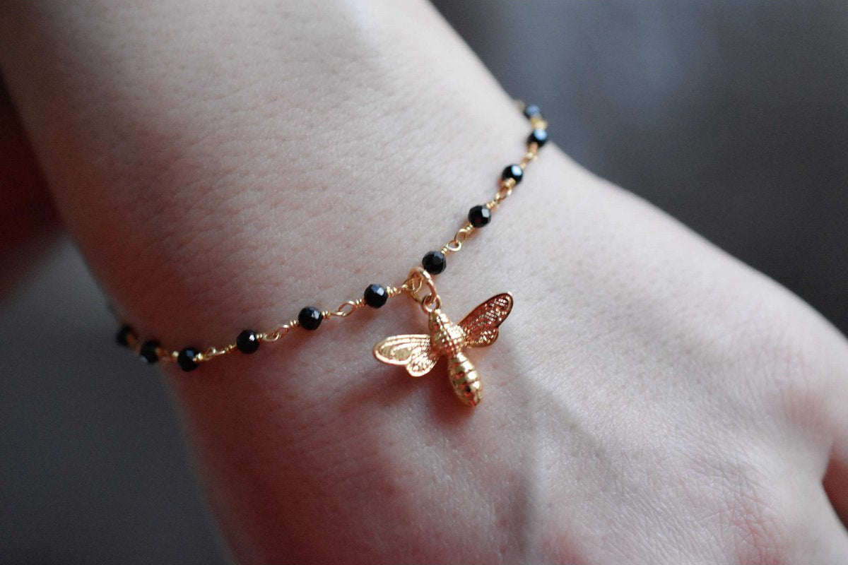 Armband mit Onyxrondellen und goldenem Bienenanhänger
