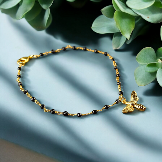 Elegantes Armband mit Onyxrondellen und goldenem Bienenanhänger