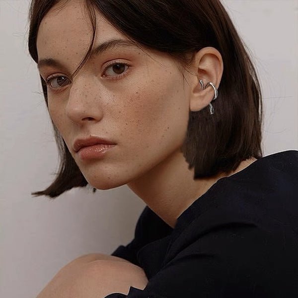 Stilvoller Floating Ear Cuff für Damen und Herren mit fließendem, ohraufsitzendem Design. Aus Messing, 18K vergoldet oder weißvergoldet.