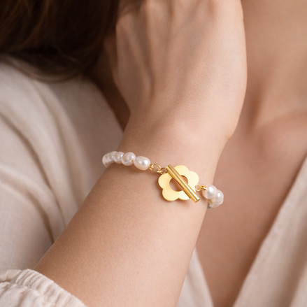 Golden Blossom Perlenarmband aus echten Süßwasserperlen mit 14 Karat vergoldeter Blumenschließe, getragen am Handgelenk