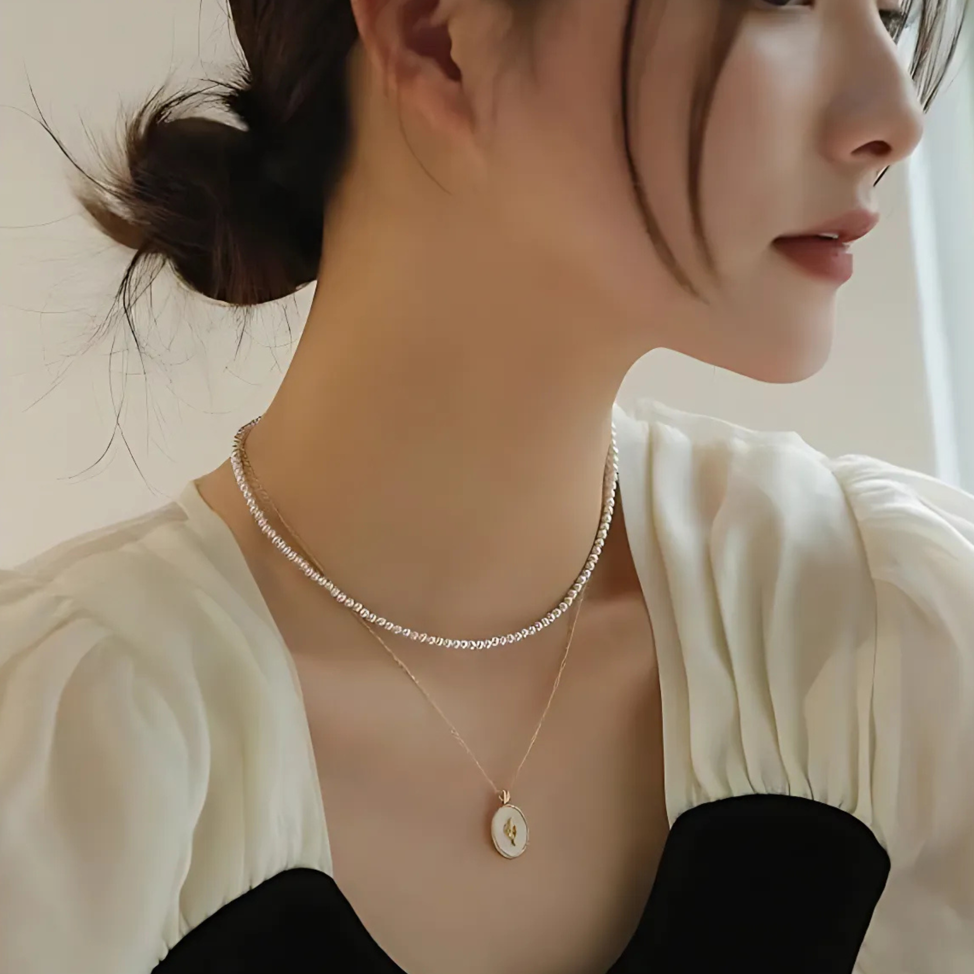 elegante Halskette vereint die filigrane Schönheit einer Tulpenblüte mit der zeitlosen Eleganz von echtem Perlmutt. Der Anhänger besticht durch ein minimalistisches Design mit vergoldetem Ovalrahmen aus 18K Gold Vermeil