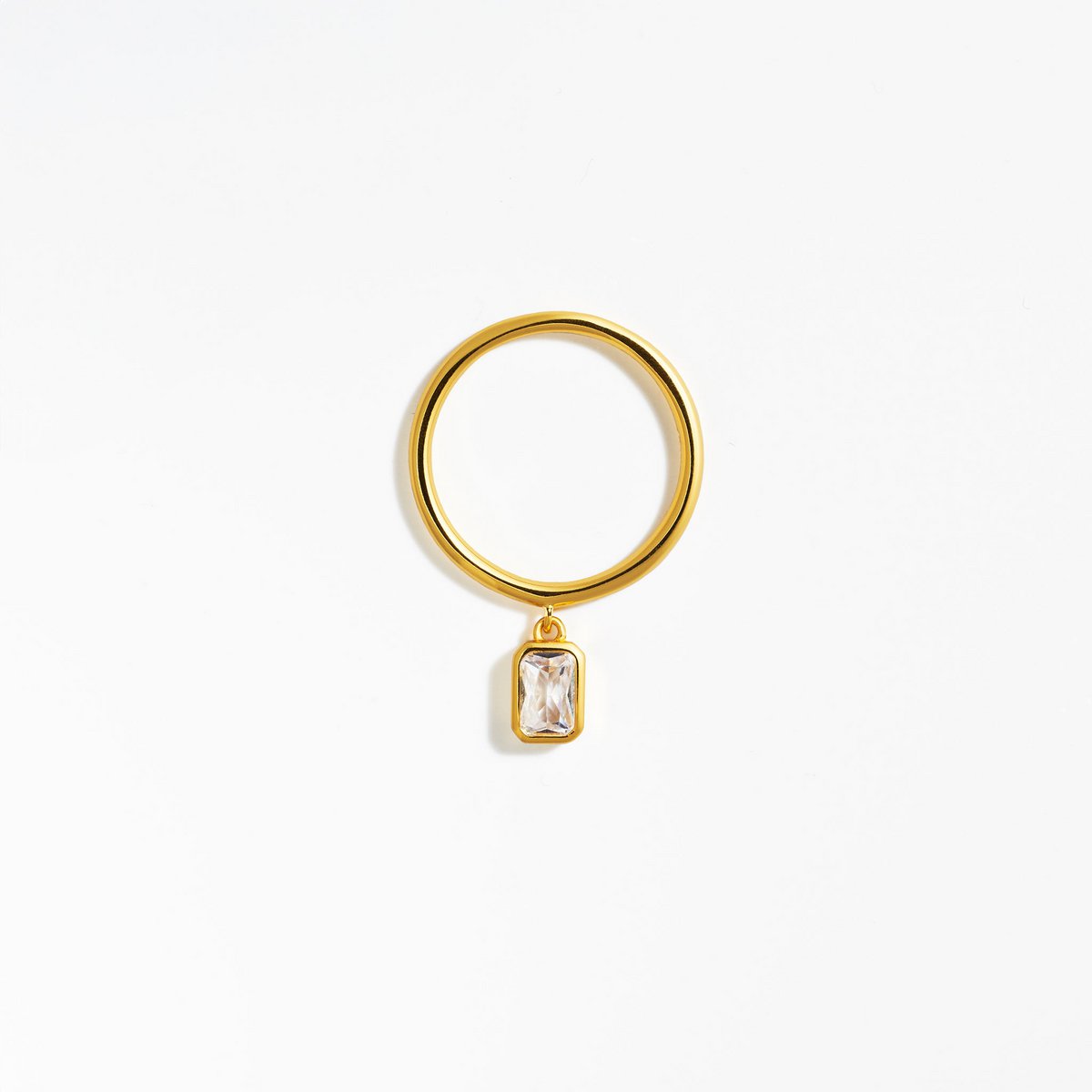 vergoldeter Ring mit baumelnden Zirkoniastein im Baguetteschliff, der am Ring befestigt ist