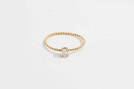 Vergoldeter Edelstahlring, gedreht und verziert, gekrönt mit einem feinen kleinen Zirkoniastein.
