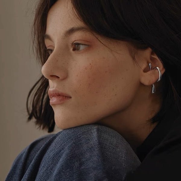 Floating Ear Cuff Silber getragen von einem Model, zeigt den minimalistischen, ohraufsitzenden Stil und den Tragekomfort.
