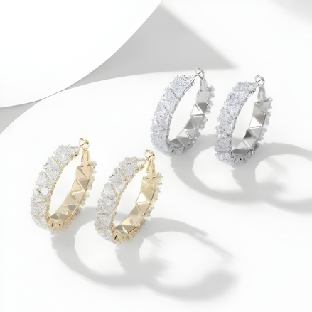 Virelle Zirkonia Creolen in Gold und Silber auf hellem Hintergrund